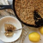 apple crisp Dutch baby pancake in cast iron skillet served in bowl with apples