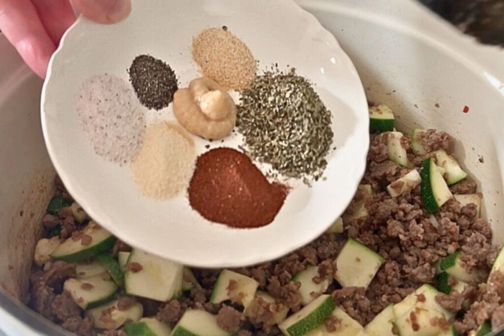 herbs and spices being added to skillet