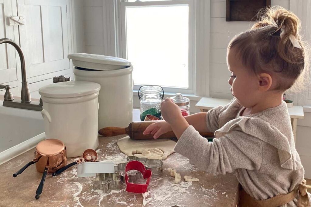 little girl cutting out sour cream sugar cookies